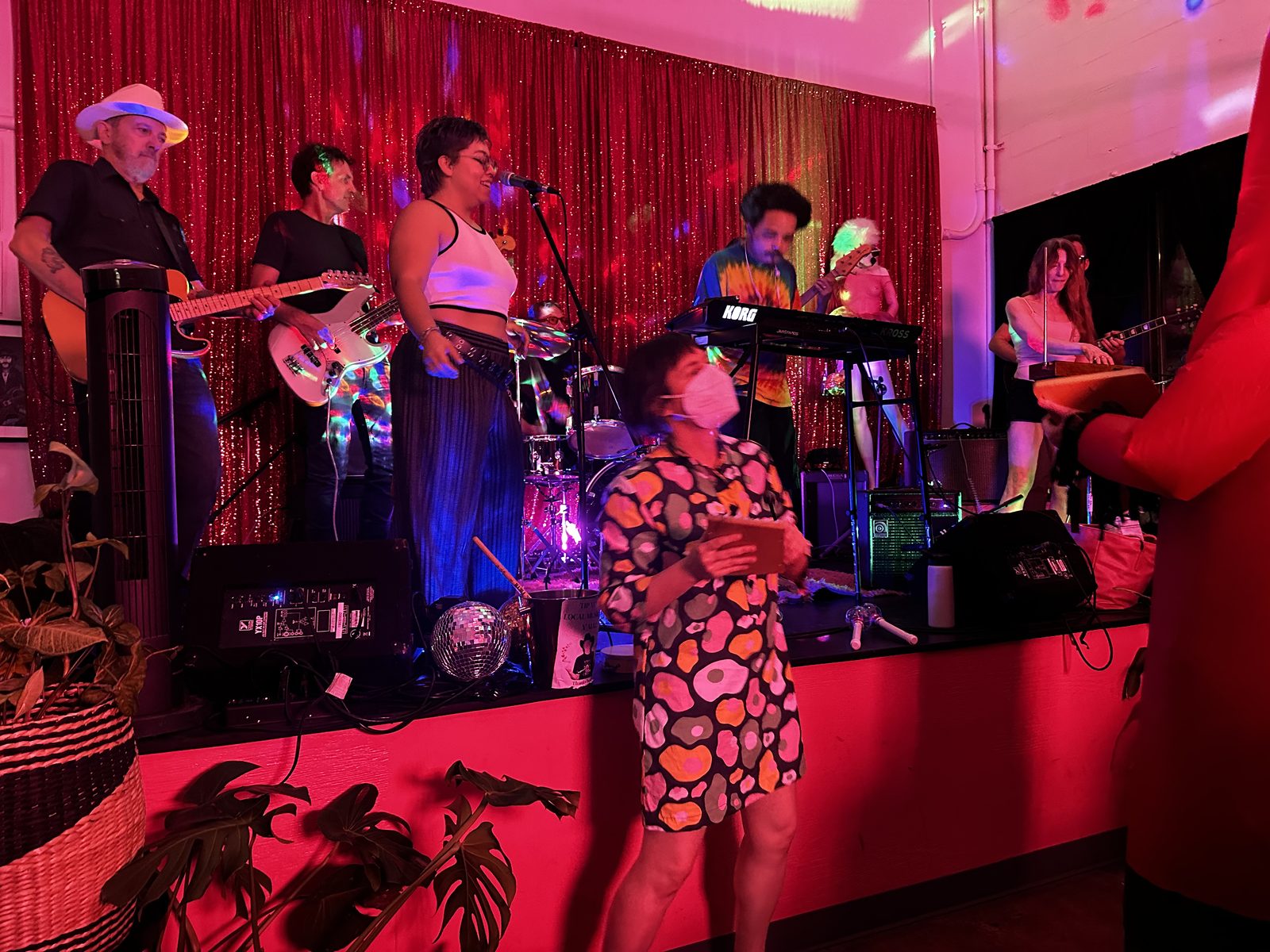 Ouiness on stage under a red glitter curtain, a larger line-up with keys, guitars and a disco ball.