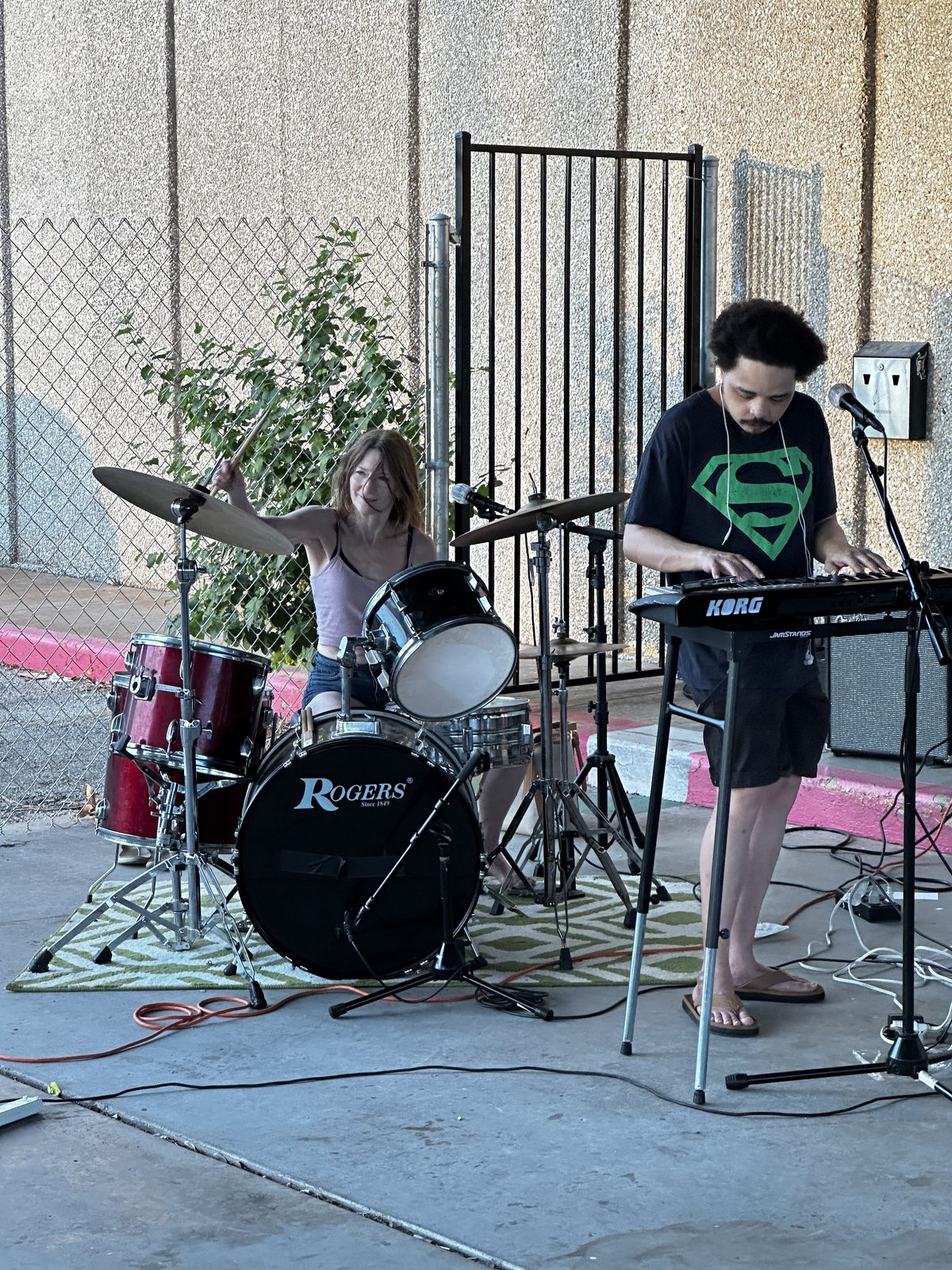 T.J. Wade and Anne Heller of jazz funk band Line of Fire, playing outdoors in the evening.