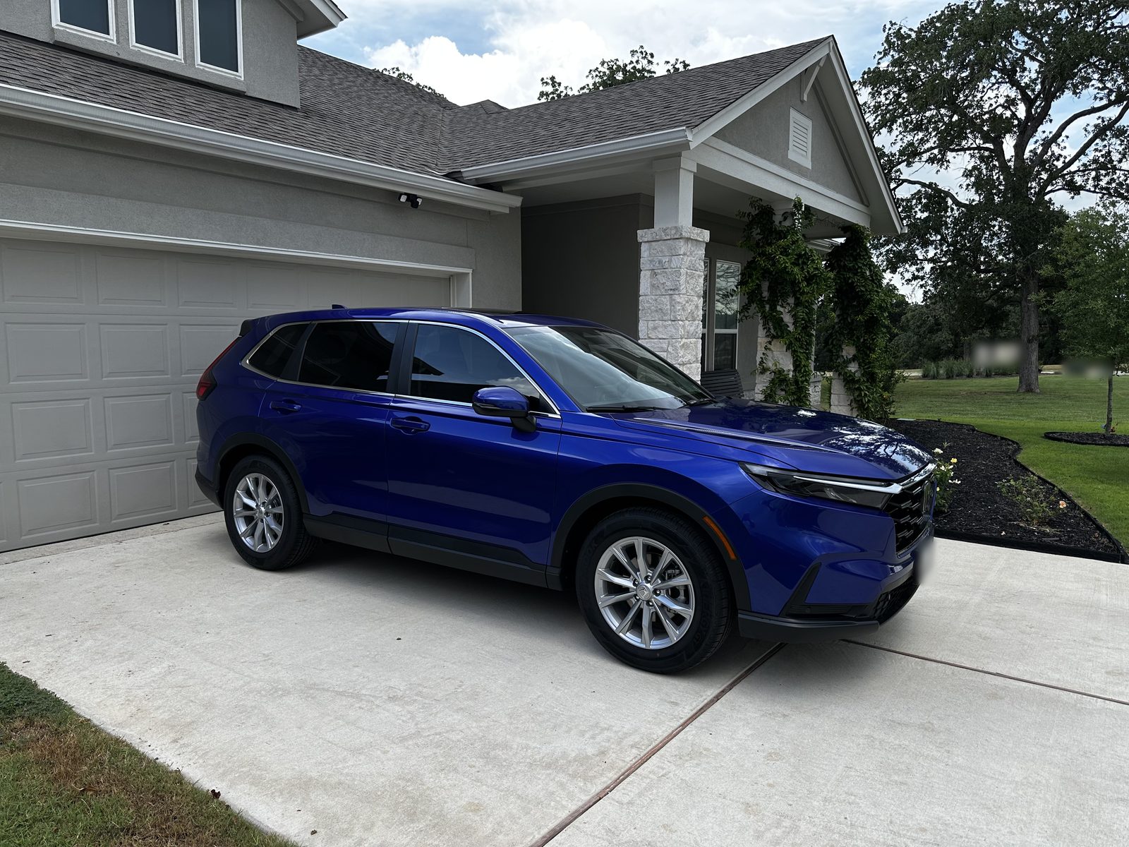 The blue SUV on the driveway at Ernie's house, the porch and garage behind it.