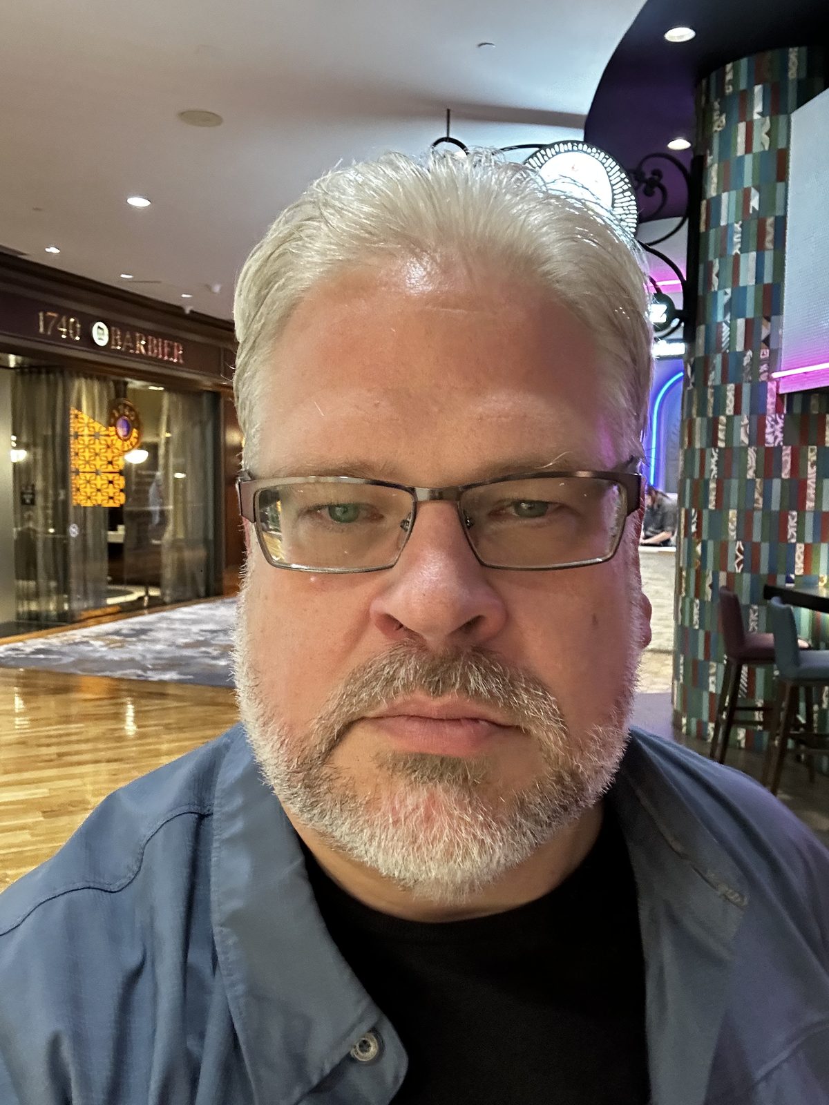 Ernie in a hotel in Lake Charles, Louisiana, a barber shop and a tiled column behind him.