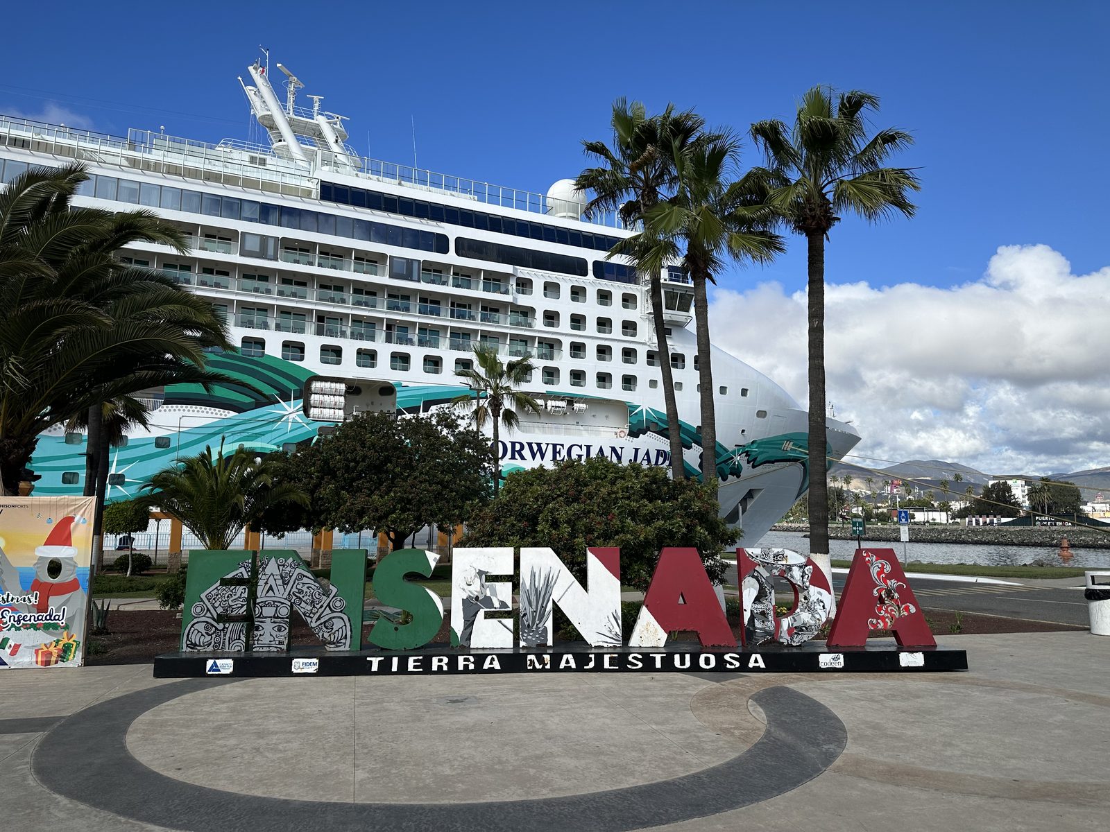 The cruise ship Norwegian Jade behind the big ENSENADA letters, palms in front.