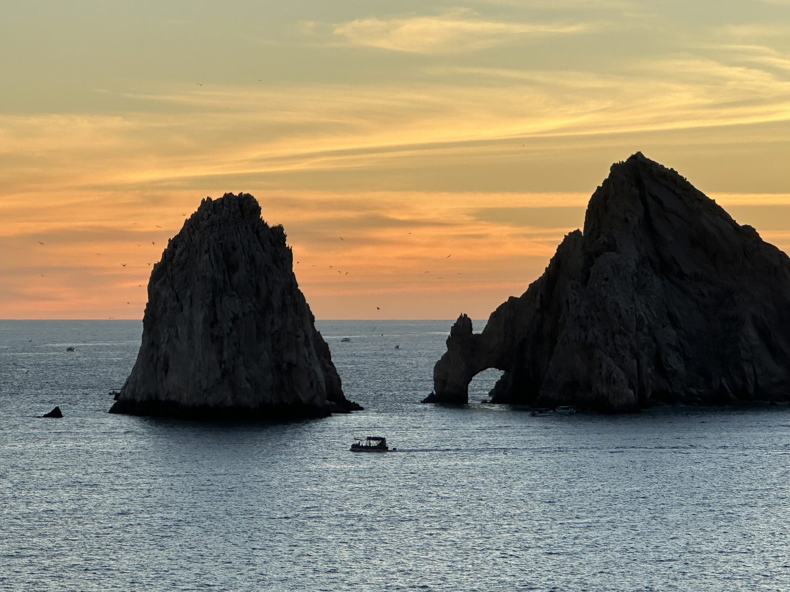 El Arco and the sea stacks at Land's End, Cabo San Lucas, a small boat passing at sunset.